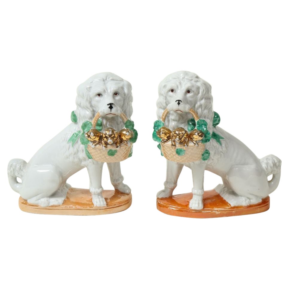 Paire de chiens en porcelaine du Staffordshire avec panier de chiens doré