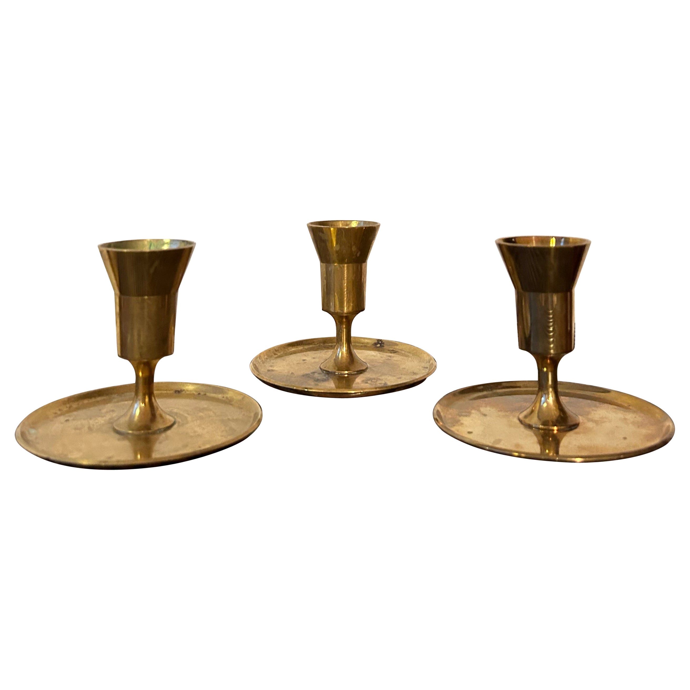 Set of three Pierre Forssell candle sticks in brass