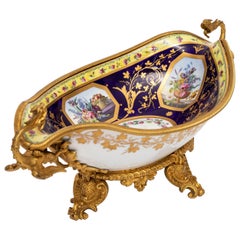 A.I.C. Centre de table en porcelaine de Sèvres montée en bronze doré avec poignées en forme de dragon.