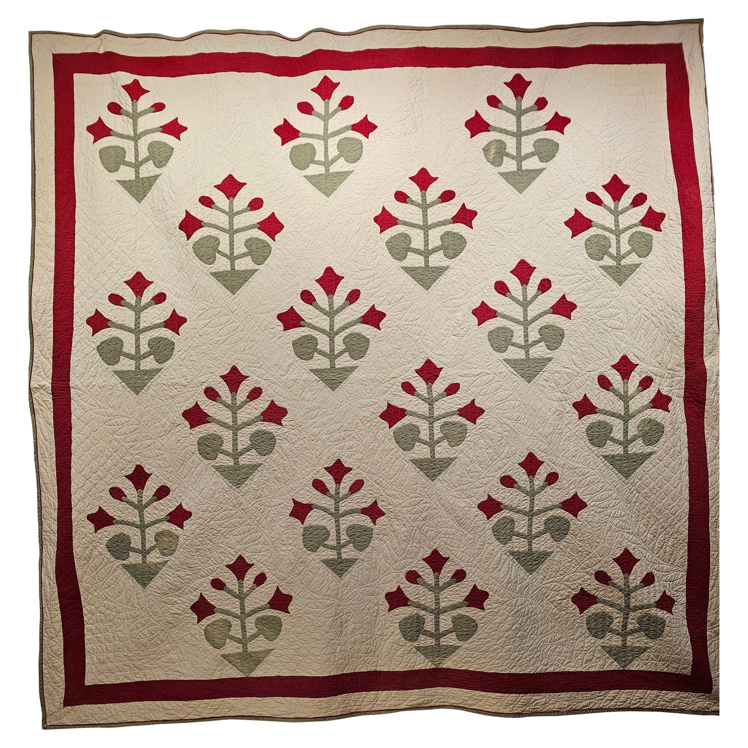 This beautiful American App;ique Quilt was hand stitched in the late 1800s in Pennsylvania in the United States. The American Applique Quilt is in “Floral” pattern with red flowers with green stems and leaves on an ivory field.  The quilt was hand