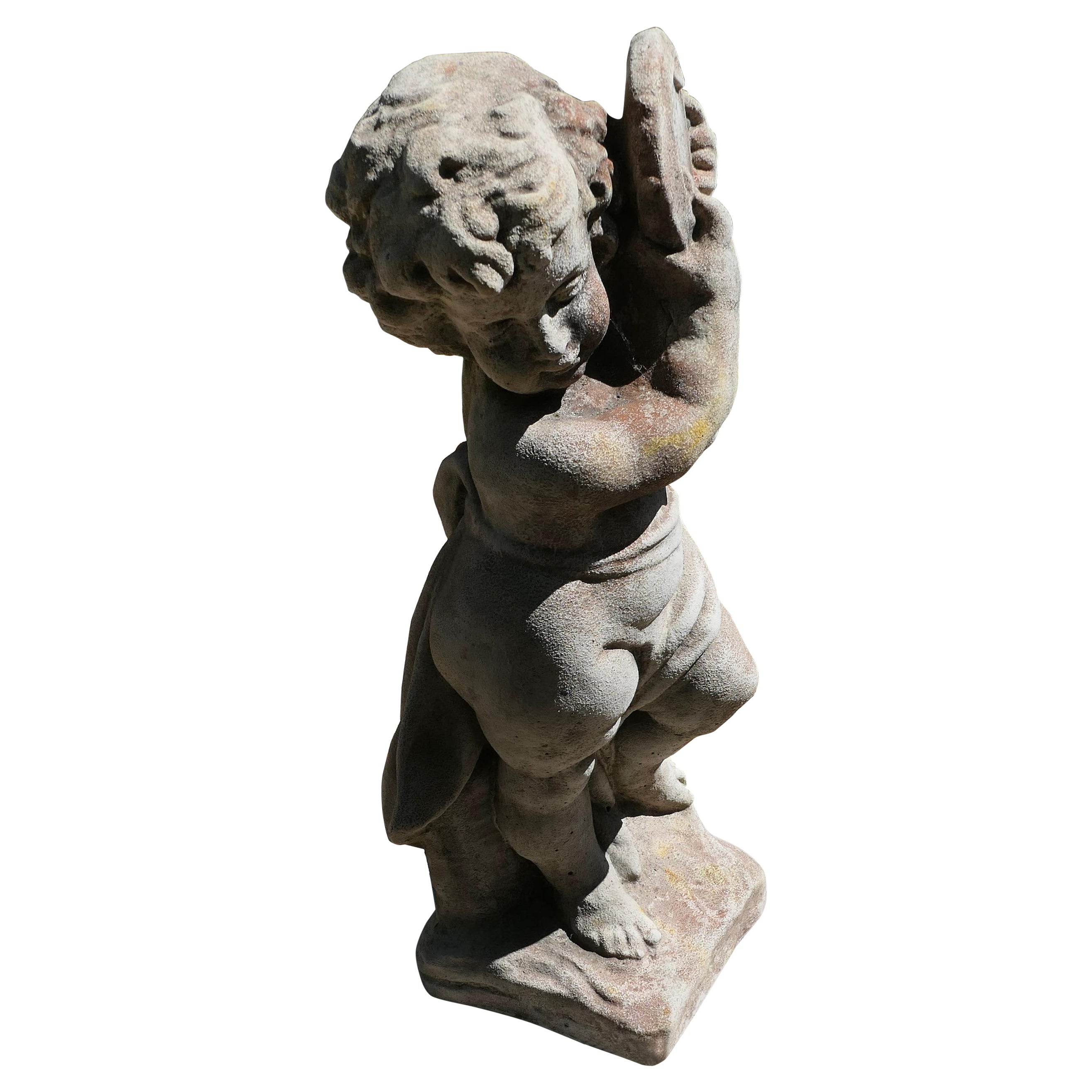 Alte verwitterte Statue einer Putte, die Tambourine spielt   