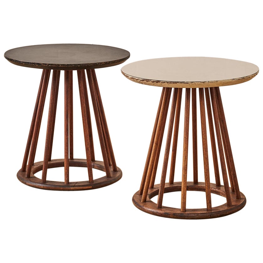 A Pair of side tables designed by Arthur Umanoff. These tables feature a sturdy walnut base with spindle details, paired with a fun mix of black and white on the round tabletops.

