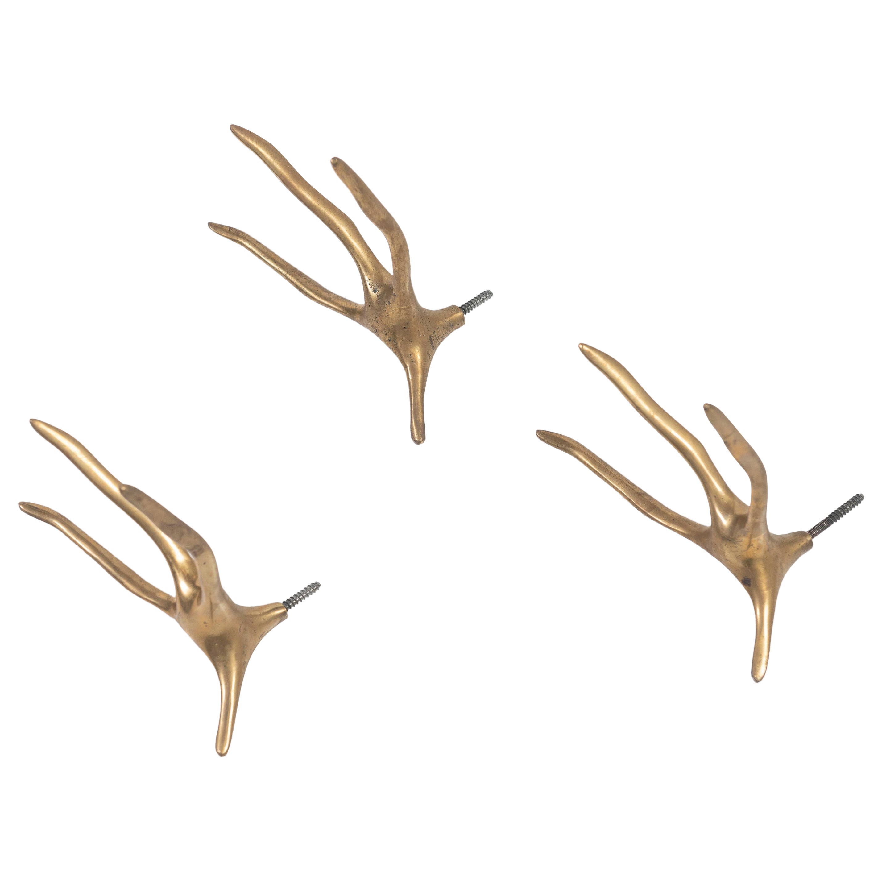 Set di tre appendiabiti da parete in ottone fuso, nello stile di Meret Oppenheim