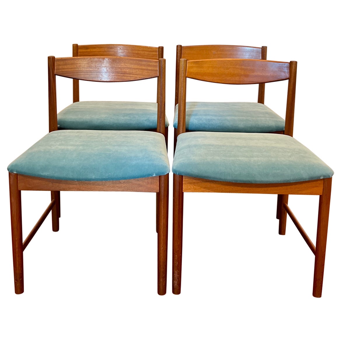 A set of four teak dining chairs by Tom Robertson for A.H McIntosh blue velvet