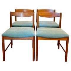 A set of four teak dining chairs by Tom Robertson for A.H McIntosh blue velvet