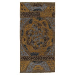 Alfombra de inspiración tribal Rug & Kilim con motivos geométricos en azul, marrón y dorado