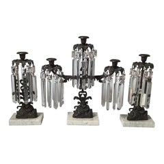 A Patinated Bronze, Marble and Crystal Three Piece Garniture Candelabra Set