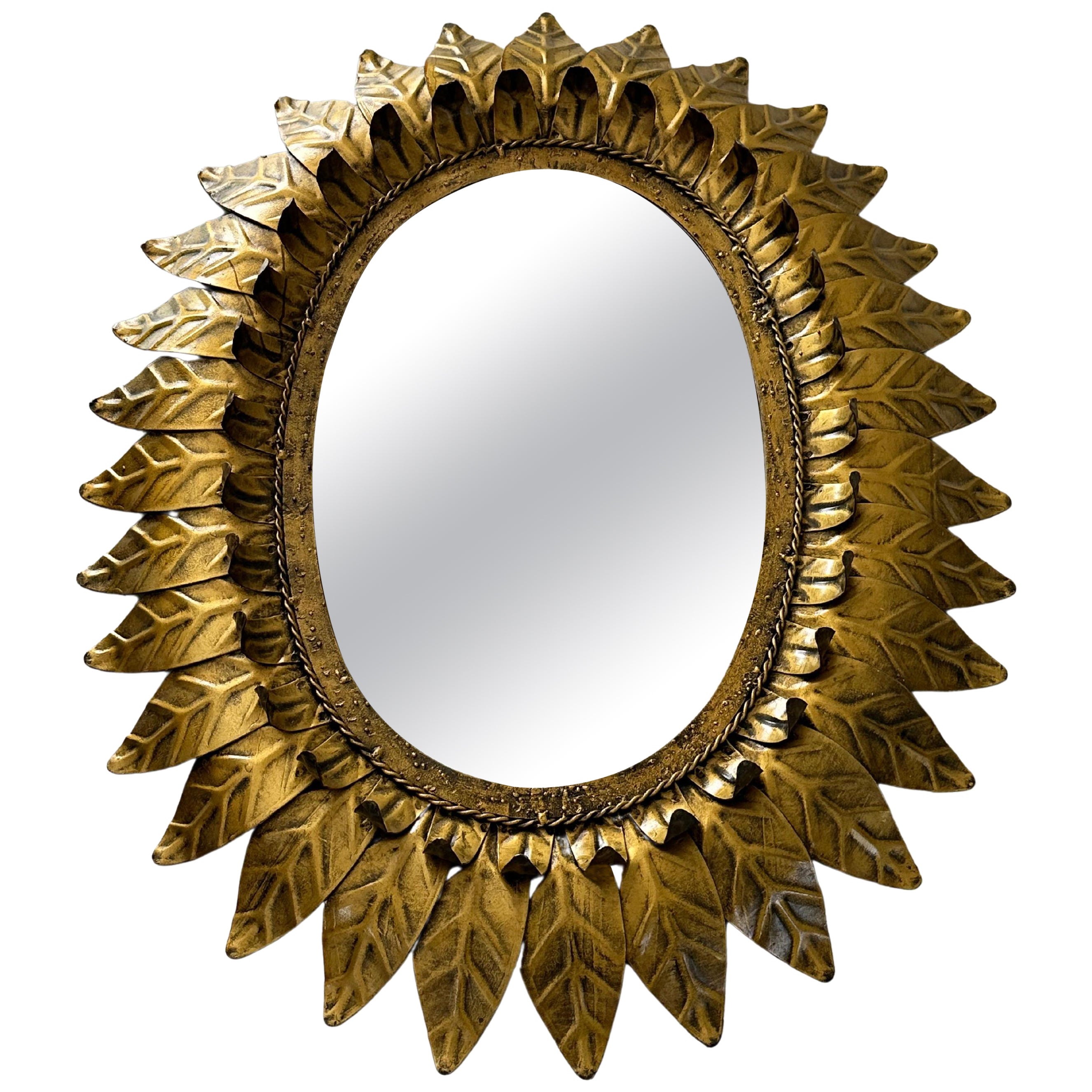 Large oval sunburst mirror, framed with gold-colored metal leaves, Spain 1960