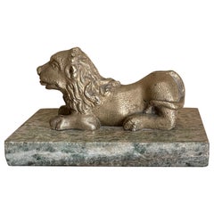 Le lion en bronze doré sur socle en marbre