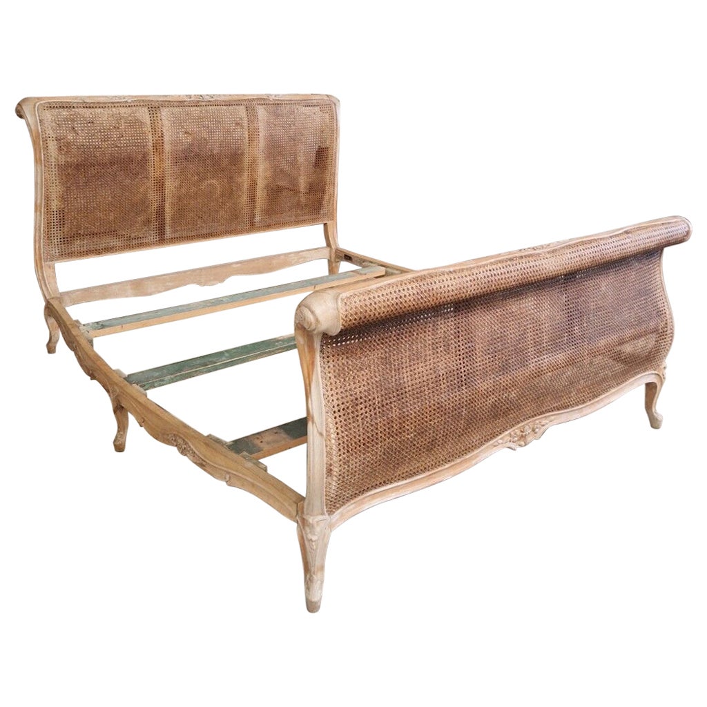 Immerse yourself in the luxury of a bygone era with this exquisite Antique French Cane Sleigh Bed from Rocaille. 
Crafted by skilled craftsmen in France during the 19th century, this rectangular-shaped bed exudes elegance and charm that is sure to