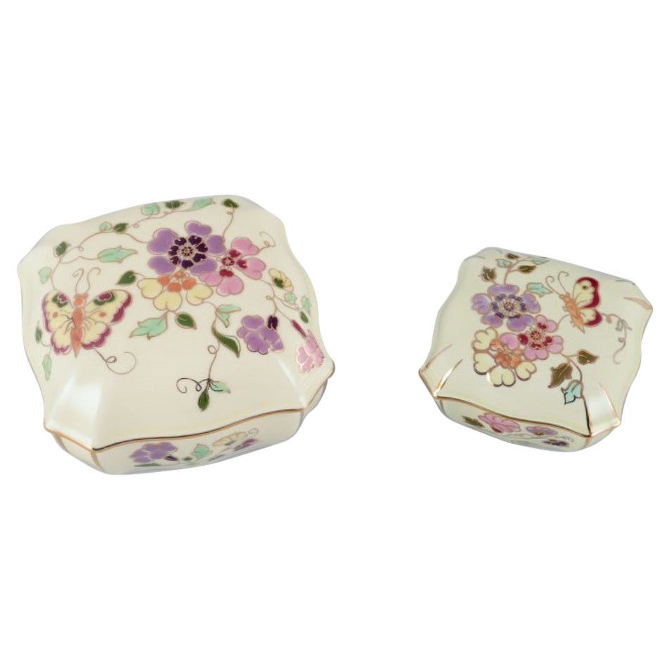 Zsolnay, Hungary, two lidded jars in porcelain hand-painted with flower motifs. For Sale