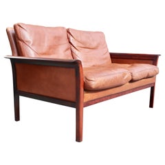 Vintage 1970s Danish tan leather two seater sofa with rosewood arms and base
