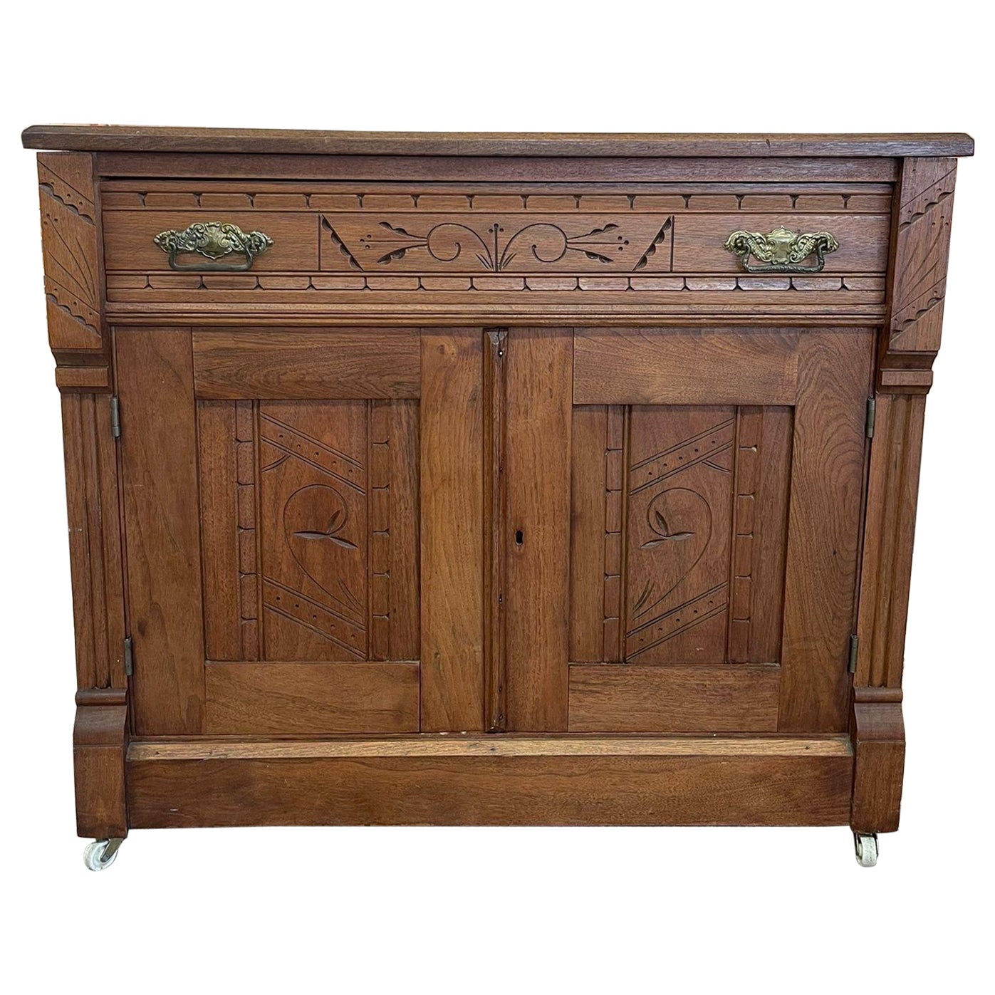 Vieille armoire victorienne en bois sculpté de style Eastlake sur roulettes. en vente