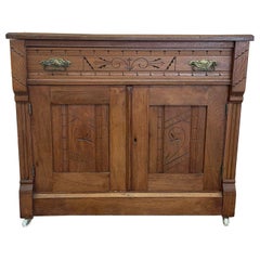 Vieille armoire victorienne en bois sculpté de style Eastlake sur roulettes.