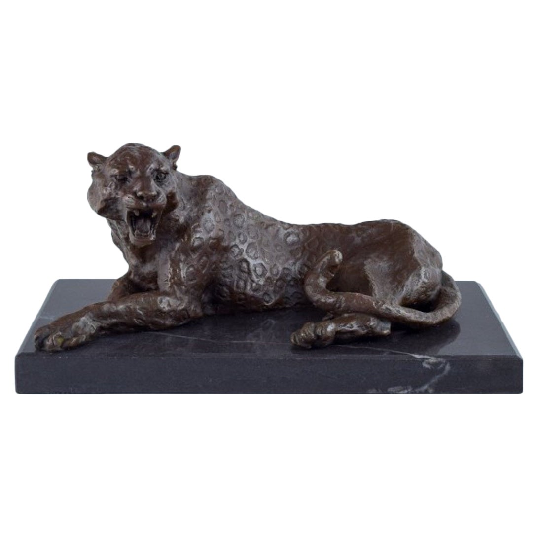 Large and heavy sculpture of a cheetah in patinated bronze on a marble base. 