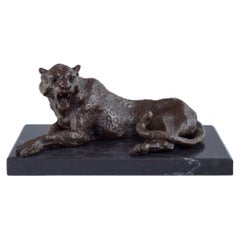 Large and heavy sculpture of a cheetah in patinated bronze on a marble base.
