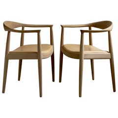A pair of 'The Chair' by Hans J Wegner (1949) in soap treated oak and leather.