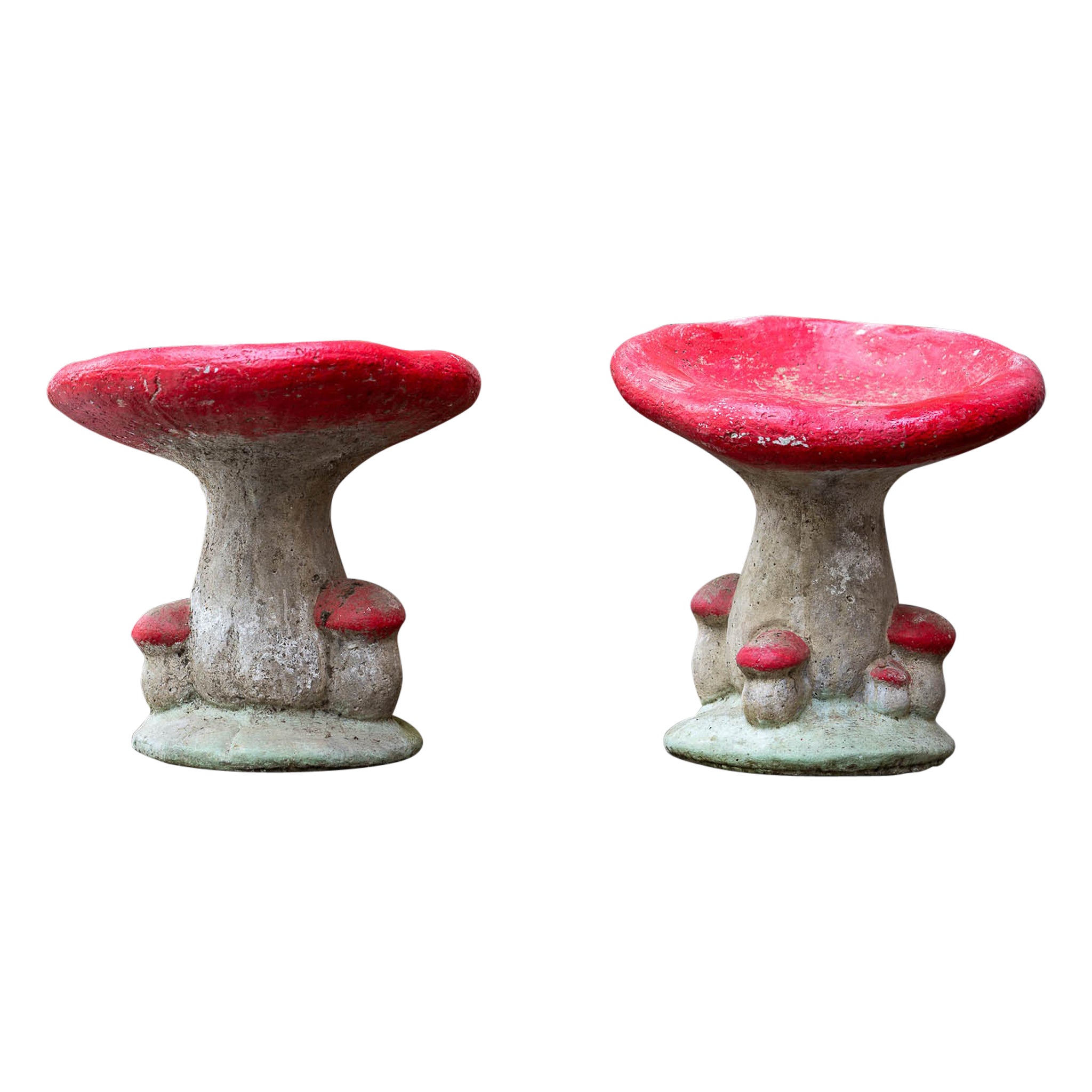 A couple of concrete Red Vintage Garden Mushrooms shaped stools with patina.