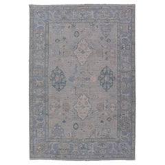 Hand-Knotted Oushak with a Light Blue-Gray Background and Tribal Motifs
