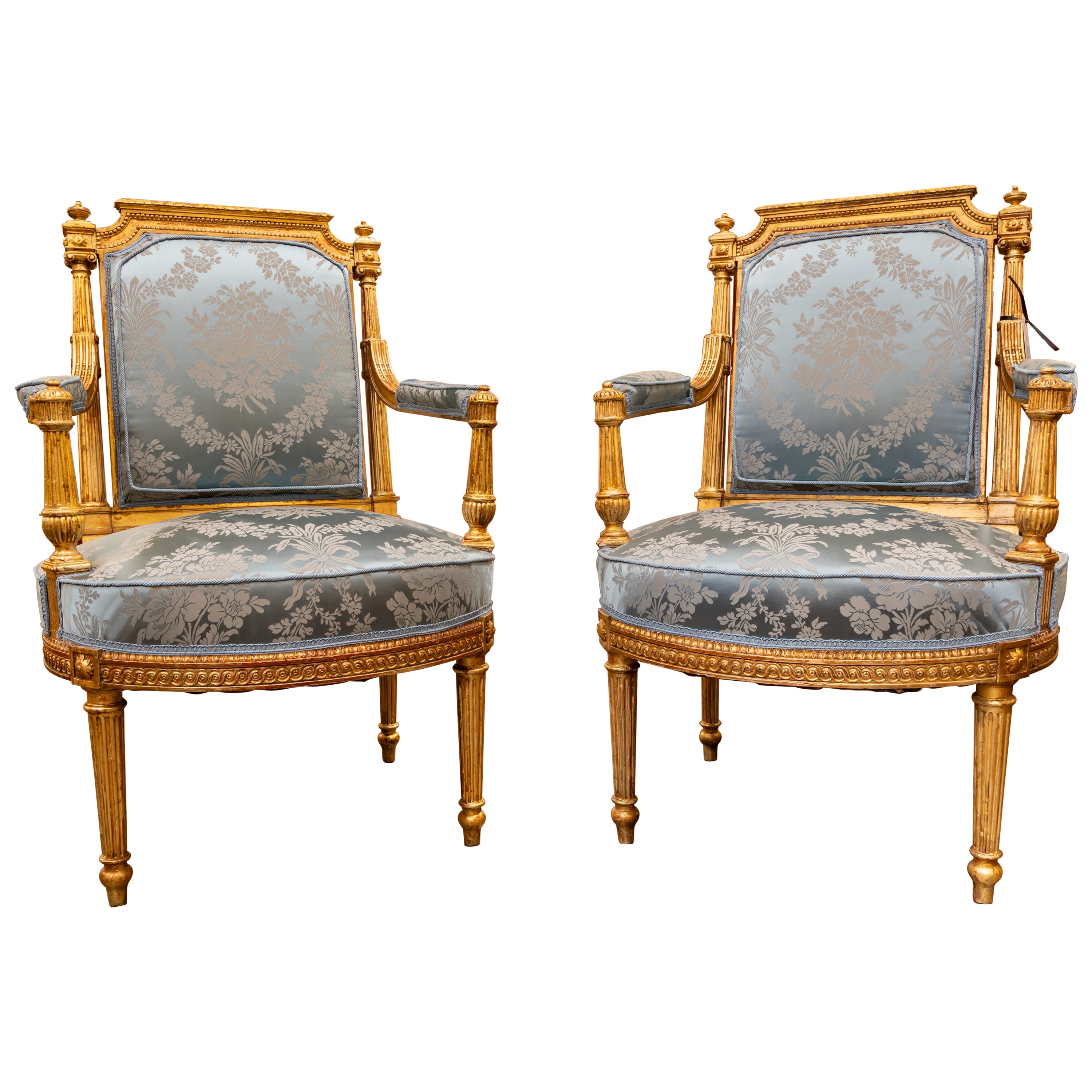 A fine pair of 19th century French Louis XVI hand carved and gilded armchairs.  For Sale