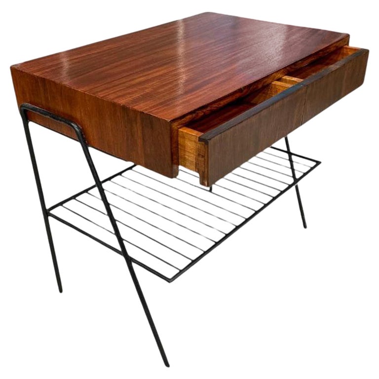 Cette table d'appoint moderne brésilienne en bois dur et métal, conçue dans les années 50, n'est rien de moins que magnifique !

La pièce possède un plateau en bois de rose brésilien et deux tiroirs fins et délicats. La base est en métal noir et
