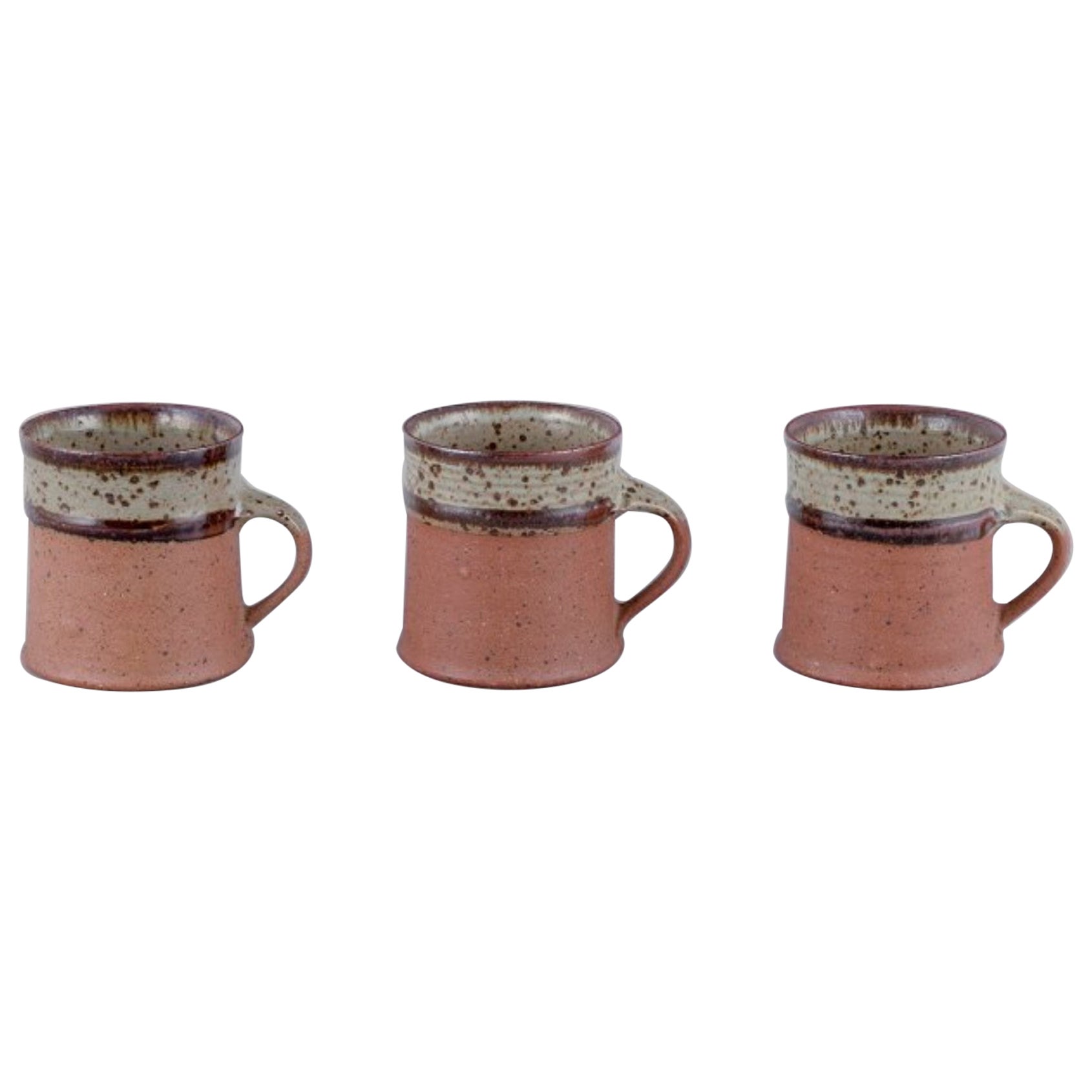 Nysted Ceramics, Dänemark. Drei Tassen aus Keramik in braunen Farbtönen.