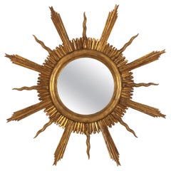Grand miroir en bois doré étoilé dans le style de Gilbert Poillerat