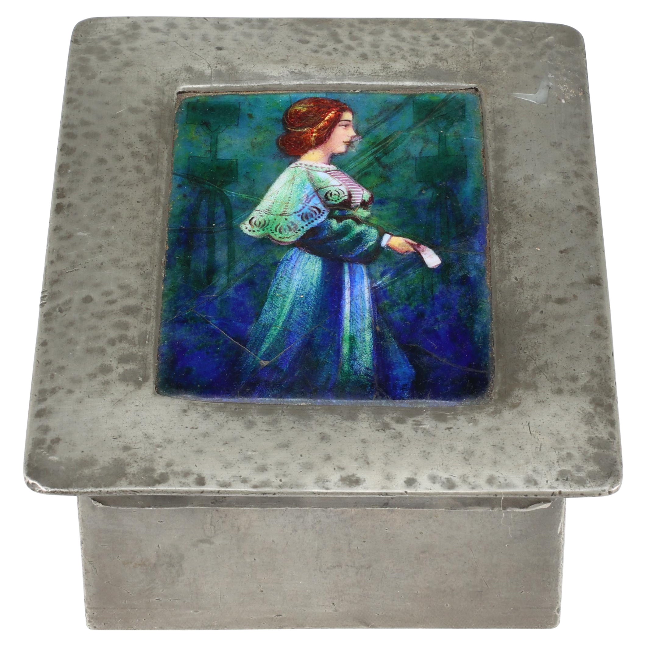 Liberty und Co. Eine Zinndose im Arts and Craft-Stil mit einer emaillierten Jungfrau auf dem Deckel. 