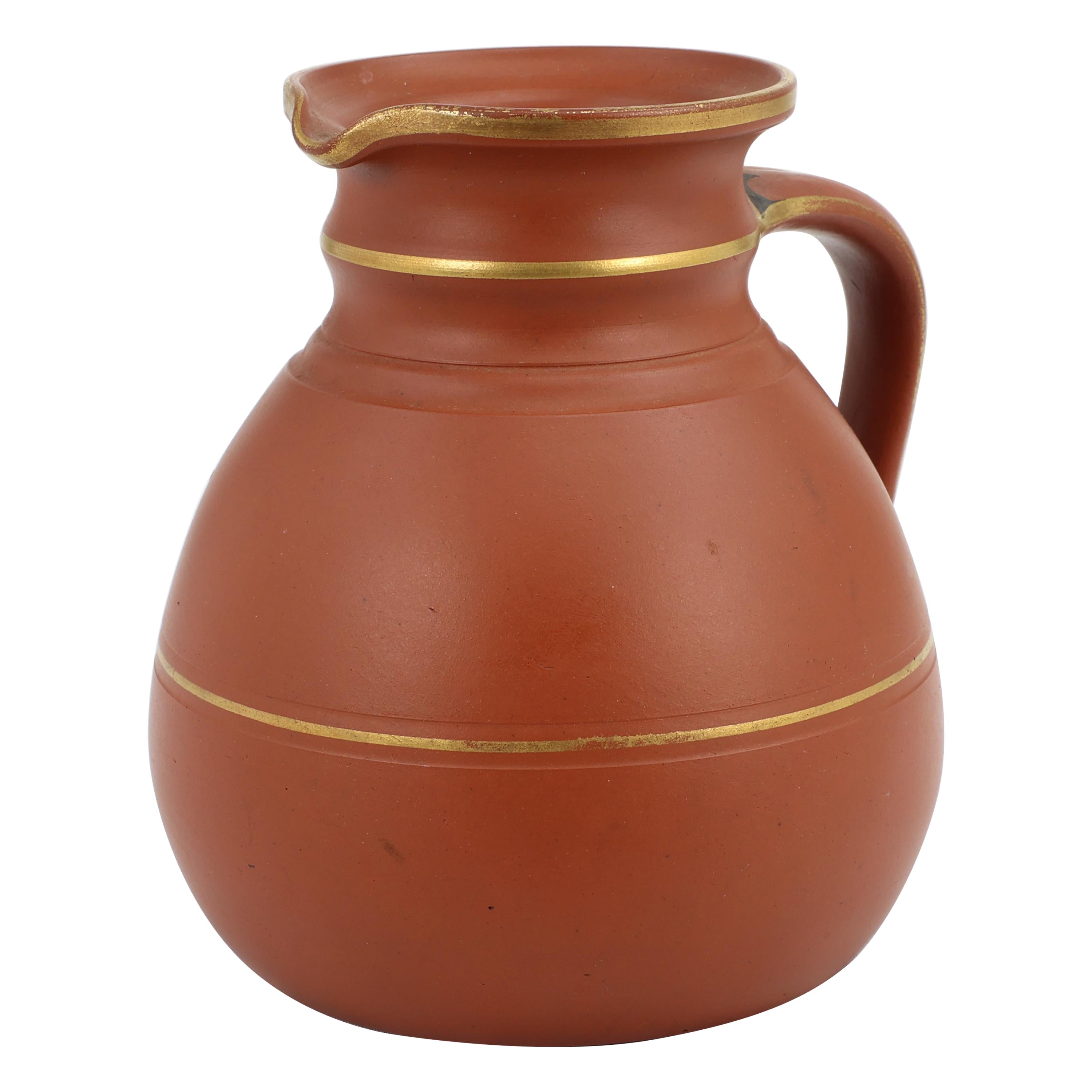 Prattware. A Gothic Revival terracotta jug with gilded line decoration. 