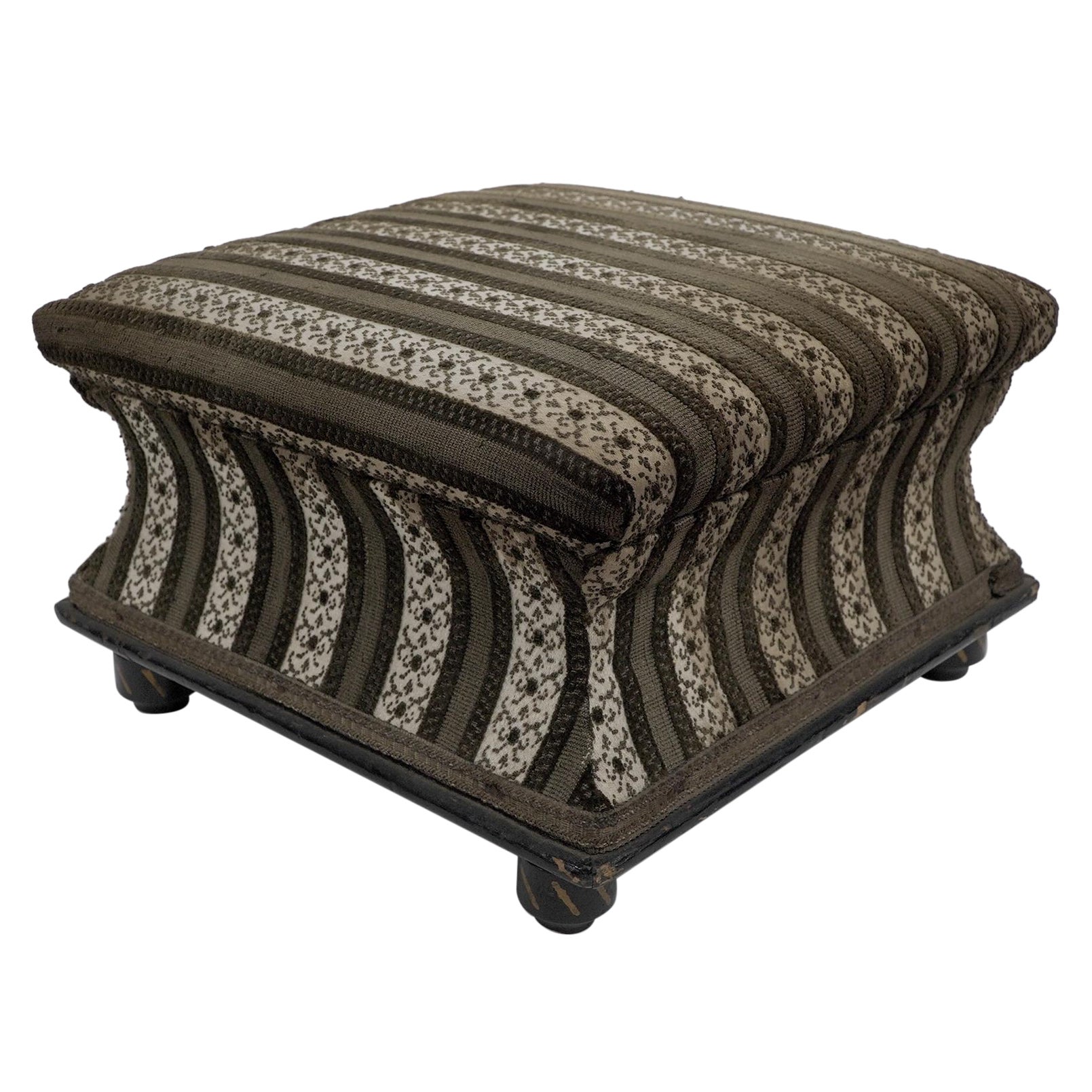 An Aesthetic Movement ebonized & gilded foot stool with striped upholstery.