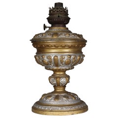An original French Rococo style cast alloy and over painted oil lamp