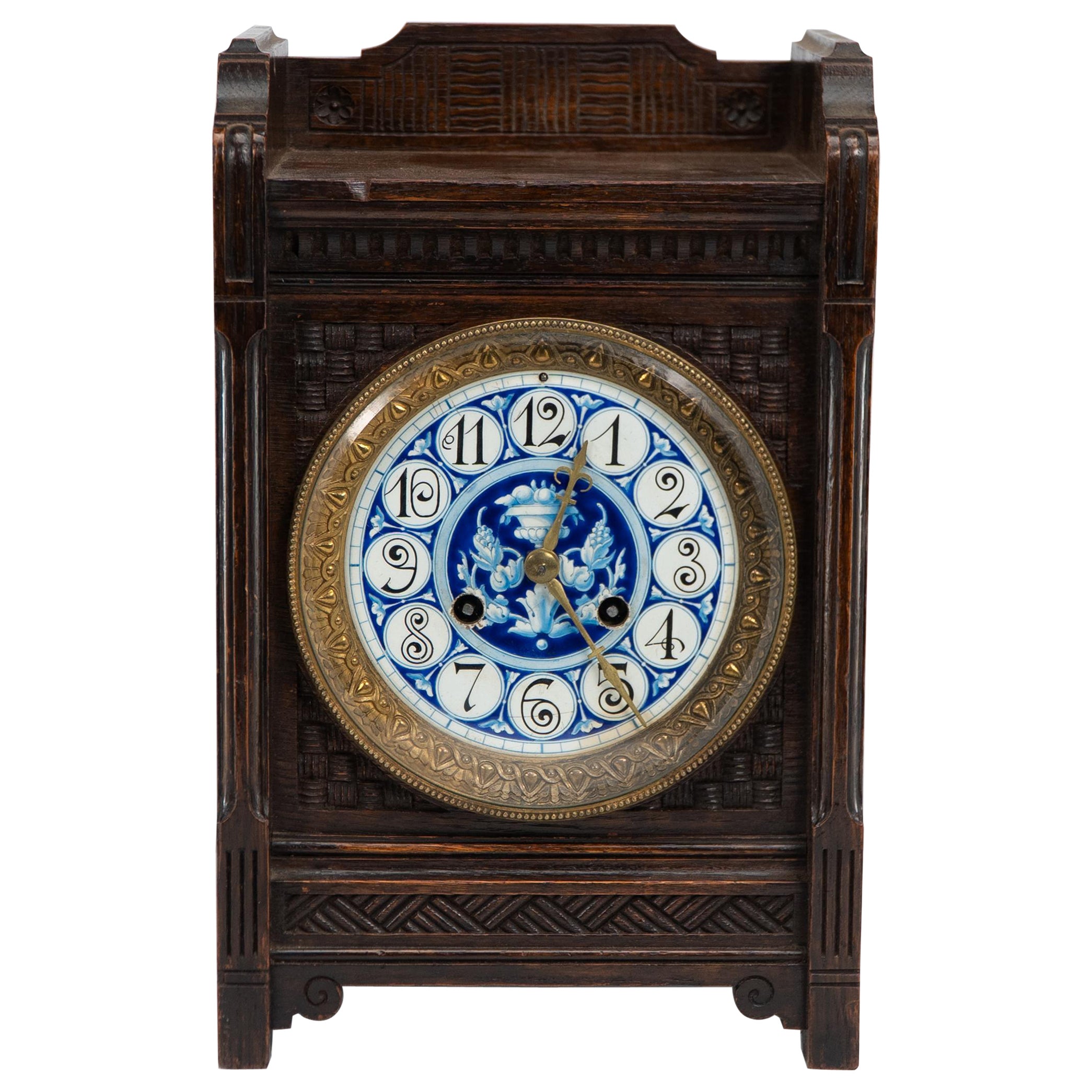 An Anglo-Japanese carved oak mantel clock with hand painted blue floral dial. For Sale