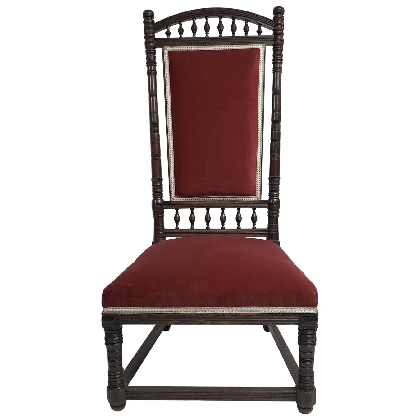 Thomas Edward Collcutt for Collinson & Lock. A fine Aesthetic Movement Walnut high back chair with later maroon upholstery. Illustrated in the Collinson and Lock catalog.
