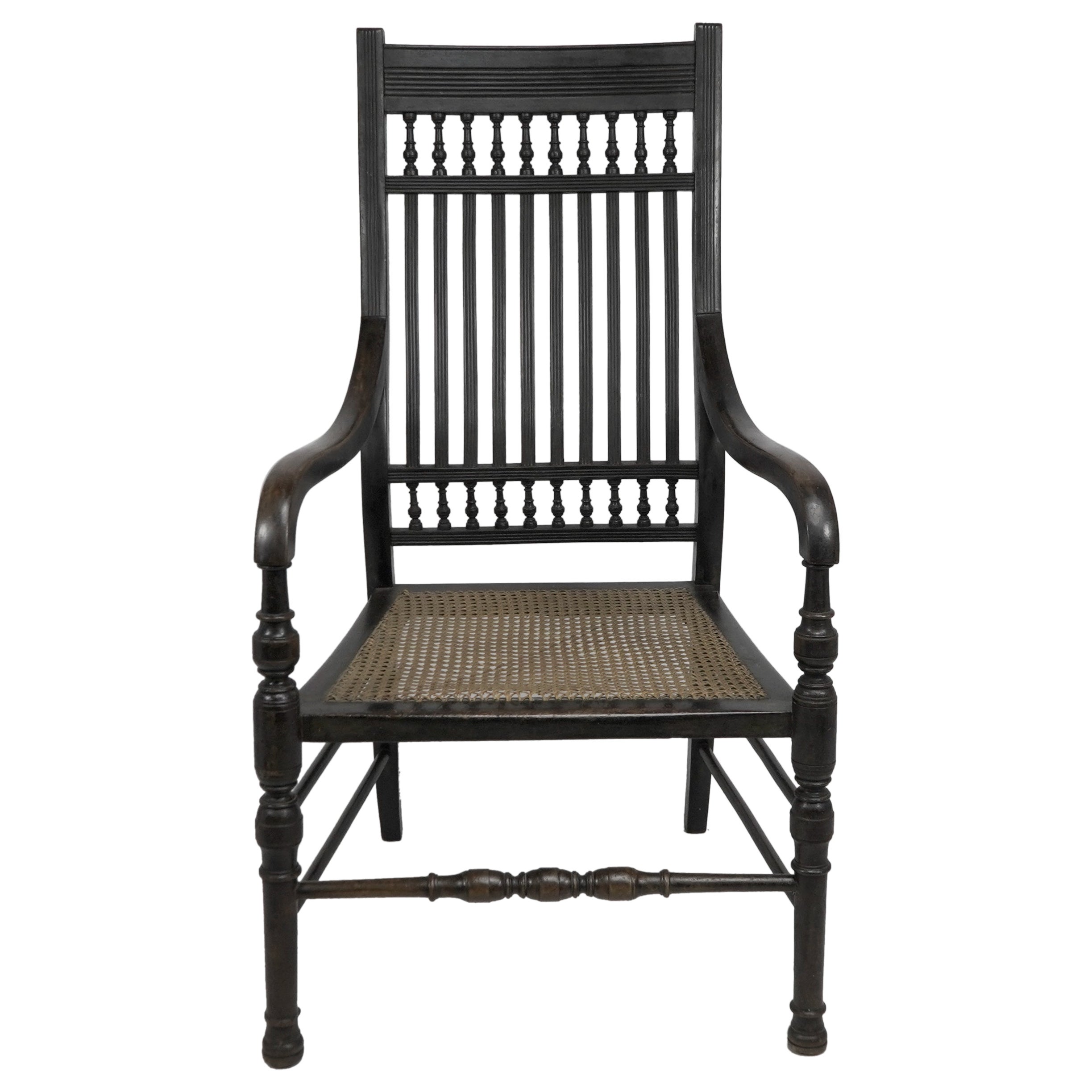 E.W. Godwin attributed, probably made by William Watt. An Aesthetic Movement tall back ebonized armchair. The turnings are in keeping with other Godwin designs, and the arms are identical to the Old English or Jacobeam armchair. The S shaped back is