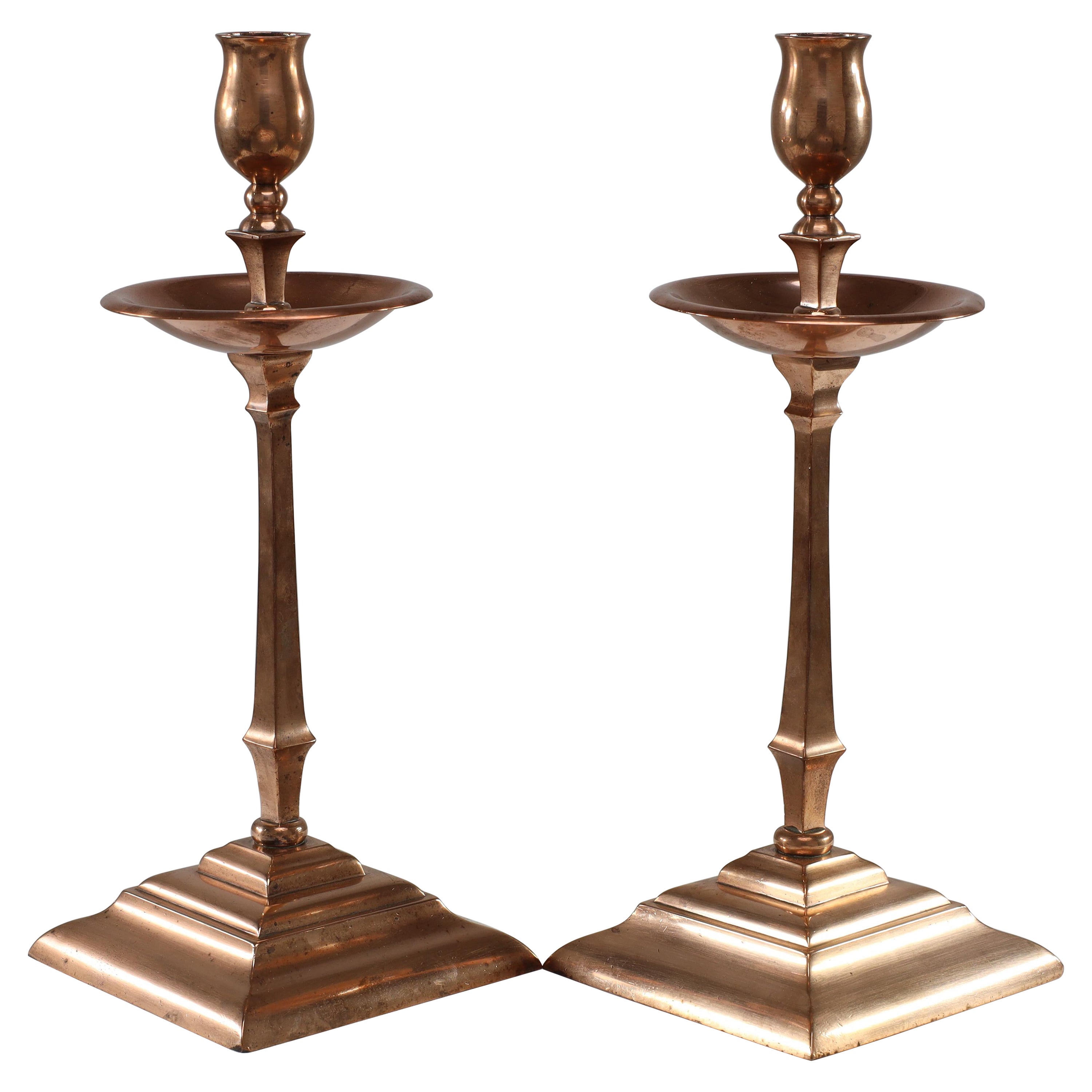 WAS Benson. A pair of Arts and Crafts copper and brass candlesticks.