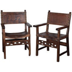 Paire de fauteuils à franges (frailero). Noyer, cuir, etc. Espagne, 17e siècle. 