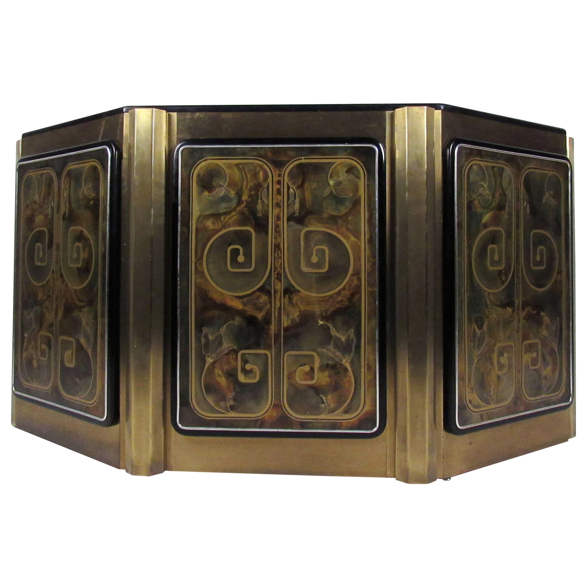 This unique Mid-Century cabinet features an artistic acid-etched floral designs on it's unique brass finish. Center door opens to access fixed shelf cabinet, unique style and shape makes this ideal for hall or entryway. 
Please confirm item location