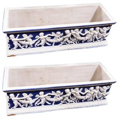 Paire de grandes boîtes de jardinière anciennes en majolique bleue et blanche avec putti