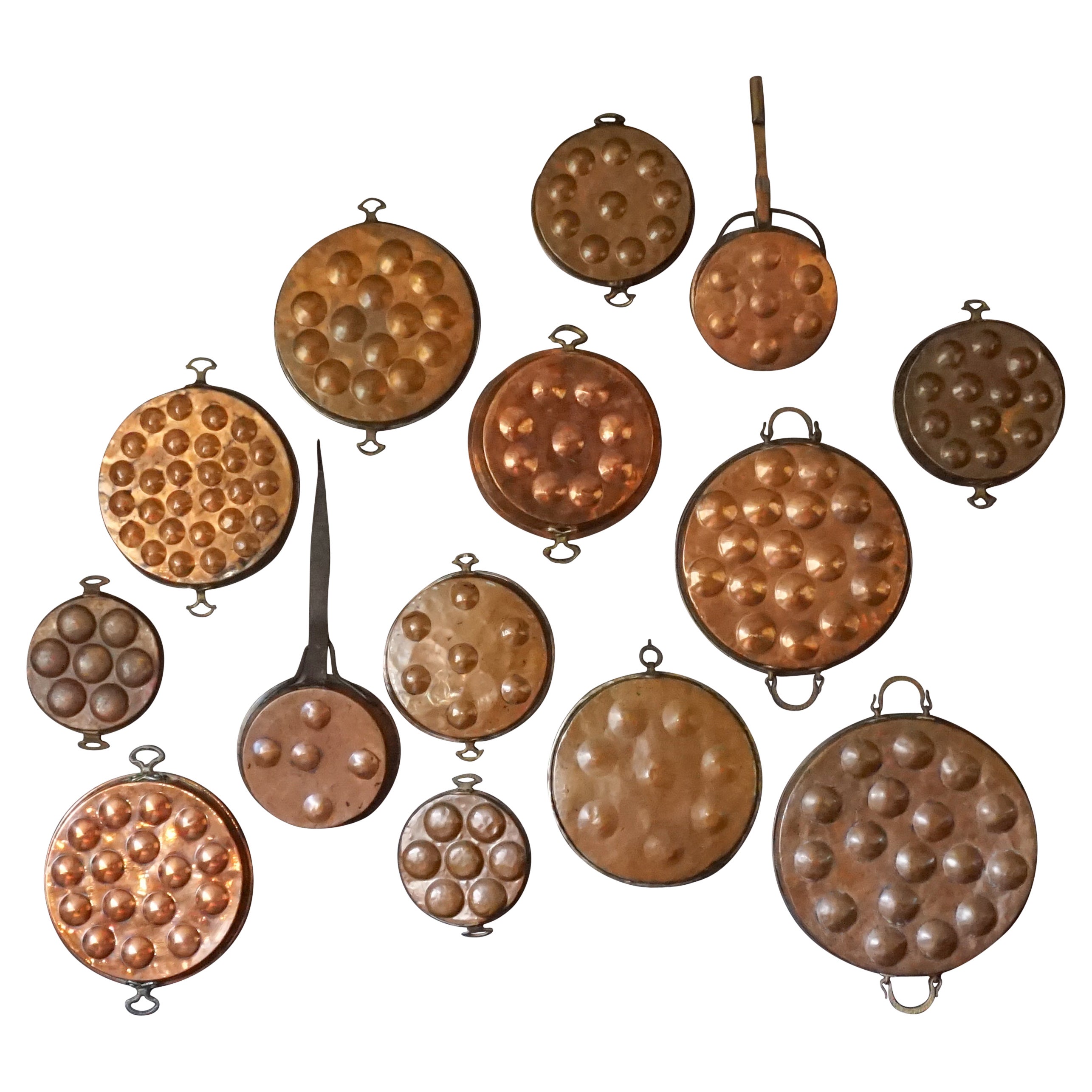 Collection of Fourteen 19th Century French Copper Egg Poacher or Escargot Pans For Sale