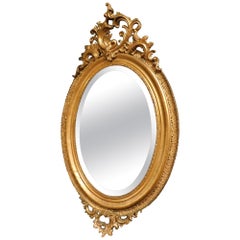 Oval mirror in gilded wood with carved cymatium, France