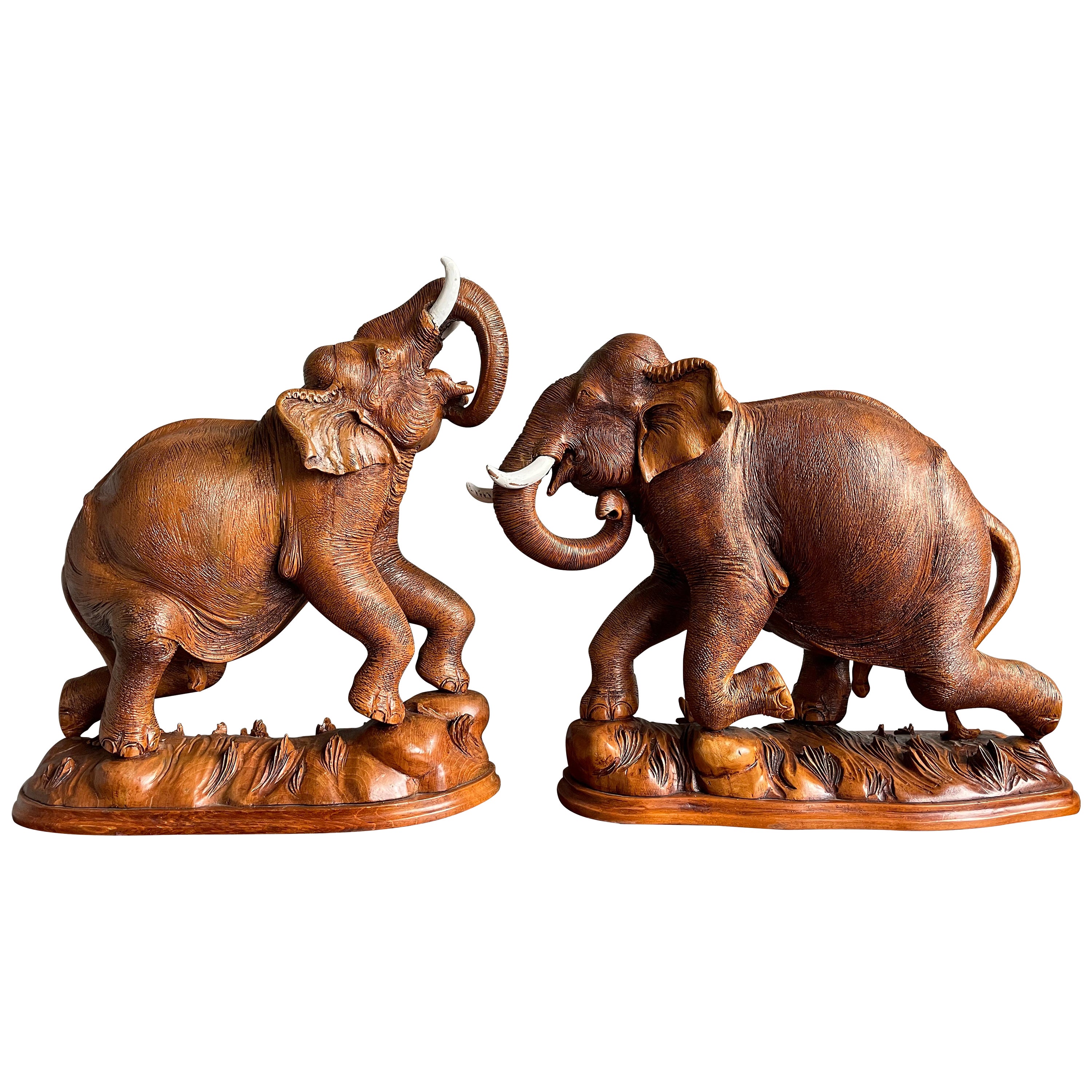 Paire de sculptures d'éléphants en teck sculptées à la main, de grande taille et incroyablement détaillées, datant du milieu du siècle dernier en vente