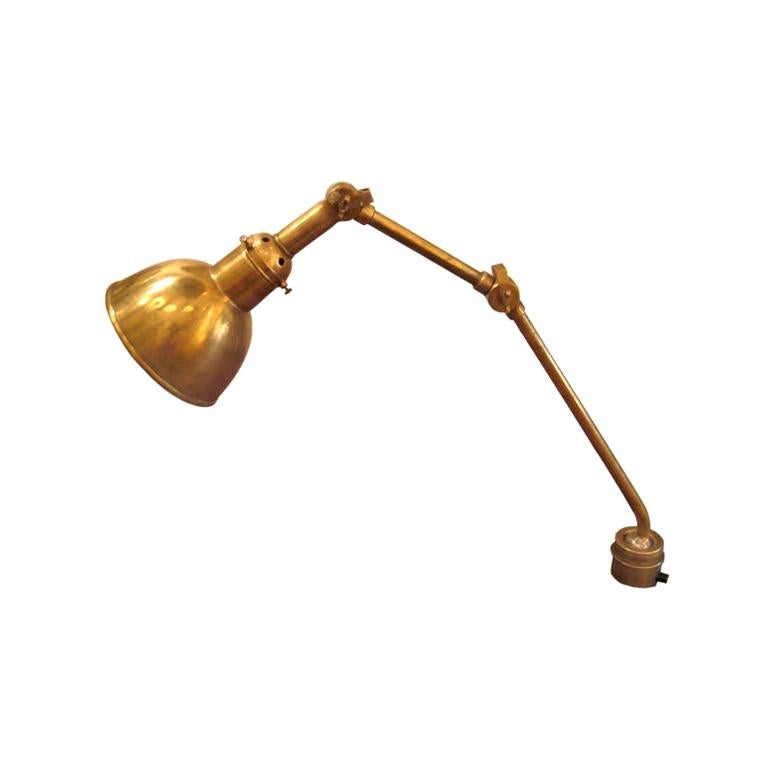 An elegant Scandinavian Modern brass desk or wall lamp from a Swedish luxury ship. This midcentury lamp articulates from three pivots. Elegant brass fittings. Will clamp to desk, wall or ceiling.