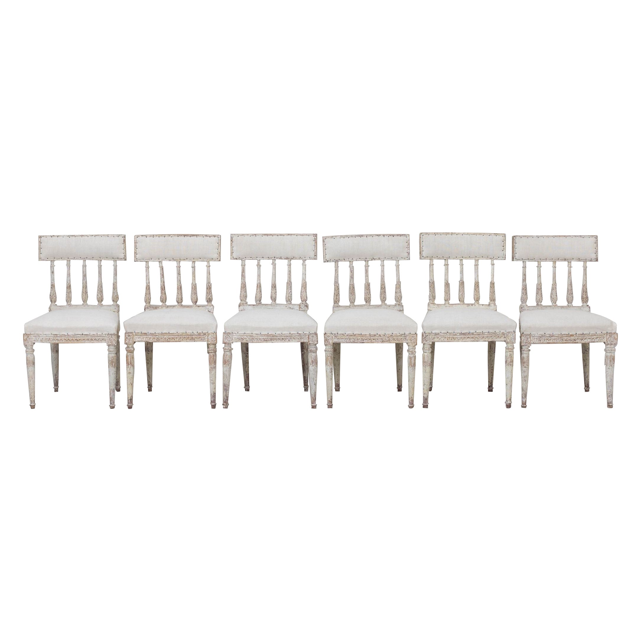 A set of six Swedish chairs from the Gustavian period in original paint, newly upholstered in antique linen. These beautiful chairs have curved splat backs, inspired by antique Roman 
