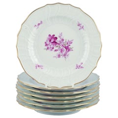 Meissen, Germania. Set di sette piatti in porcellana dipinti a mano con fiori viola
