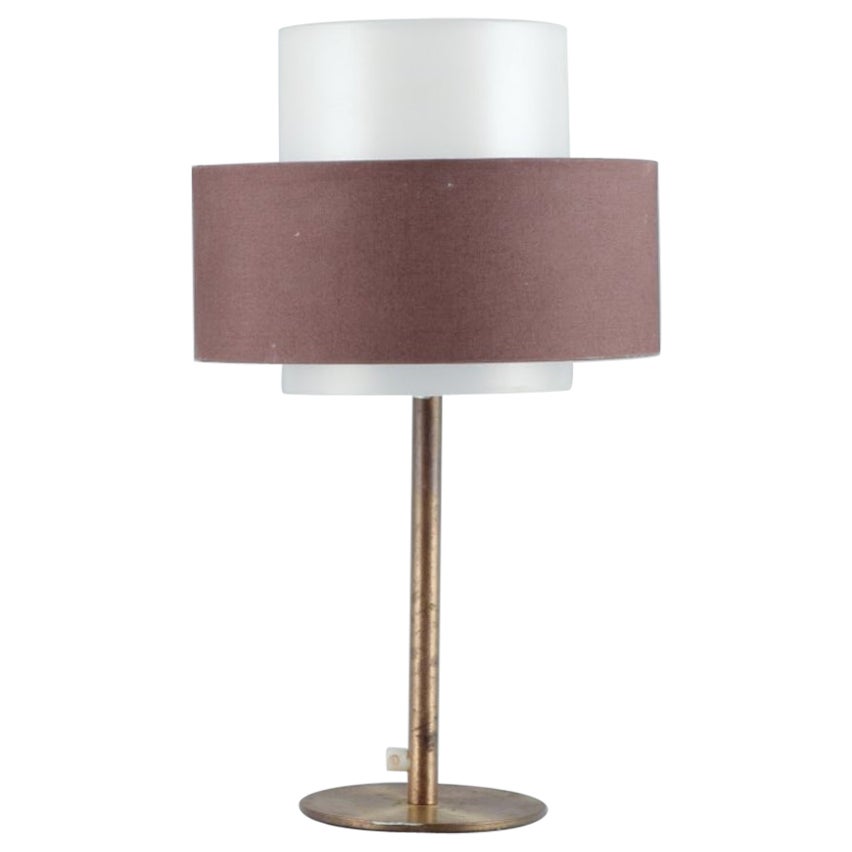 Luxus, Sweden. Large table lamp in brass with shade in plastic and brown fabric.