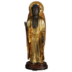 Bouddha debout japonais ou tibétain sculpté en bois doré polychrome et son Stand, 19ème C.