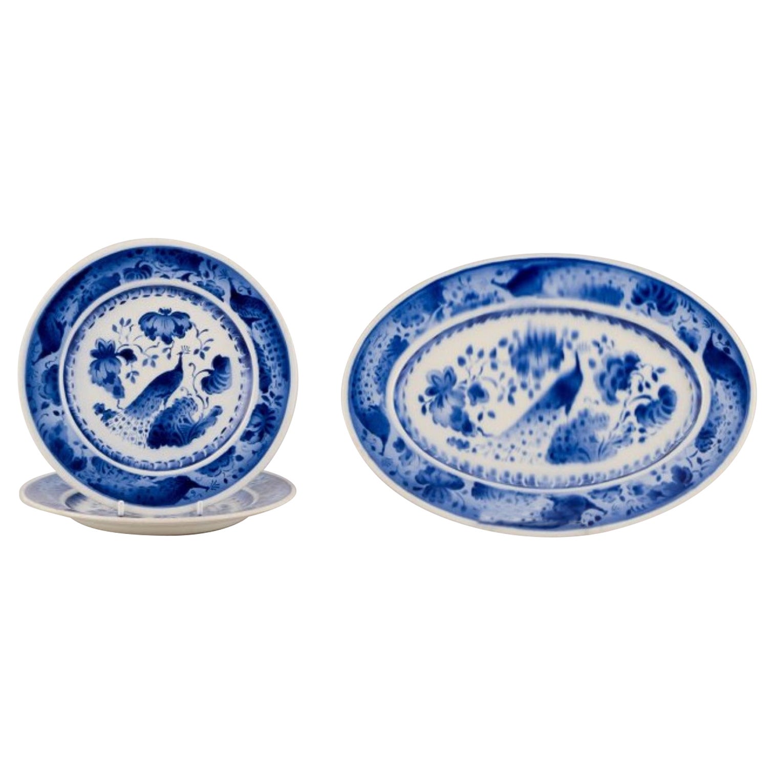 Aluminia, Denmark. Oval dish and two plates in faience. Peacock pattern.