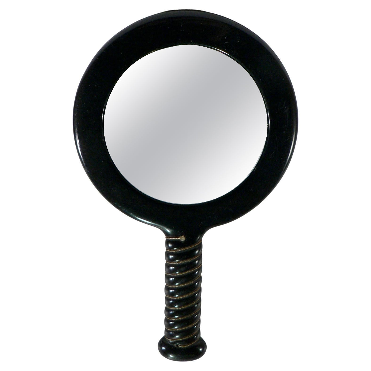 A black Bakelite handheld mirror double-sided - France - 1950.