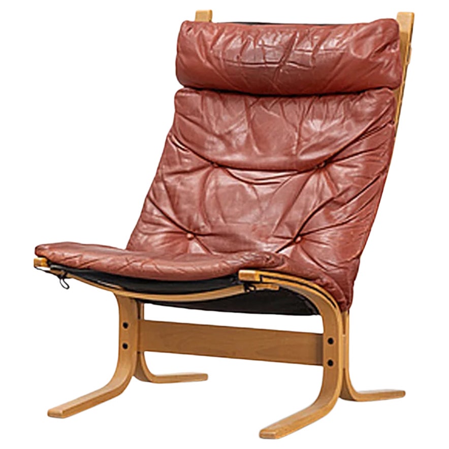 Highback "Siesta" lounge chairs in rust toned leather + beech For Sale