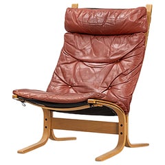 Highback "Siesta" lounge chairs in rust toned leather + beech